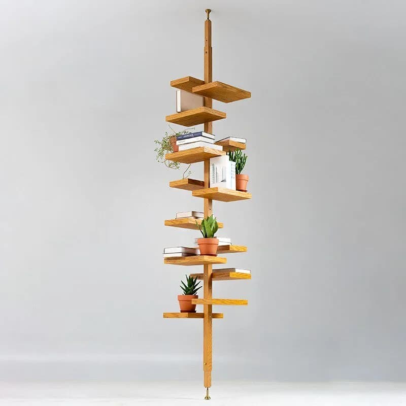 A minimalist mid-century solid wood floor-to-ceiling bookshelf with rotating square tray shelves holding plants and books.