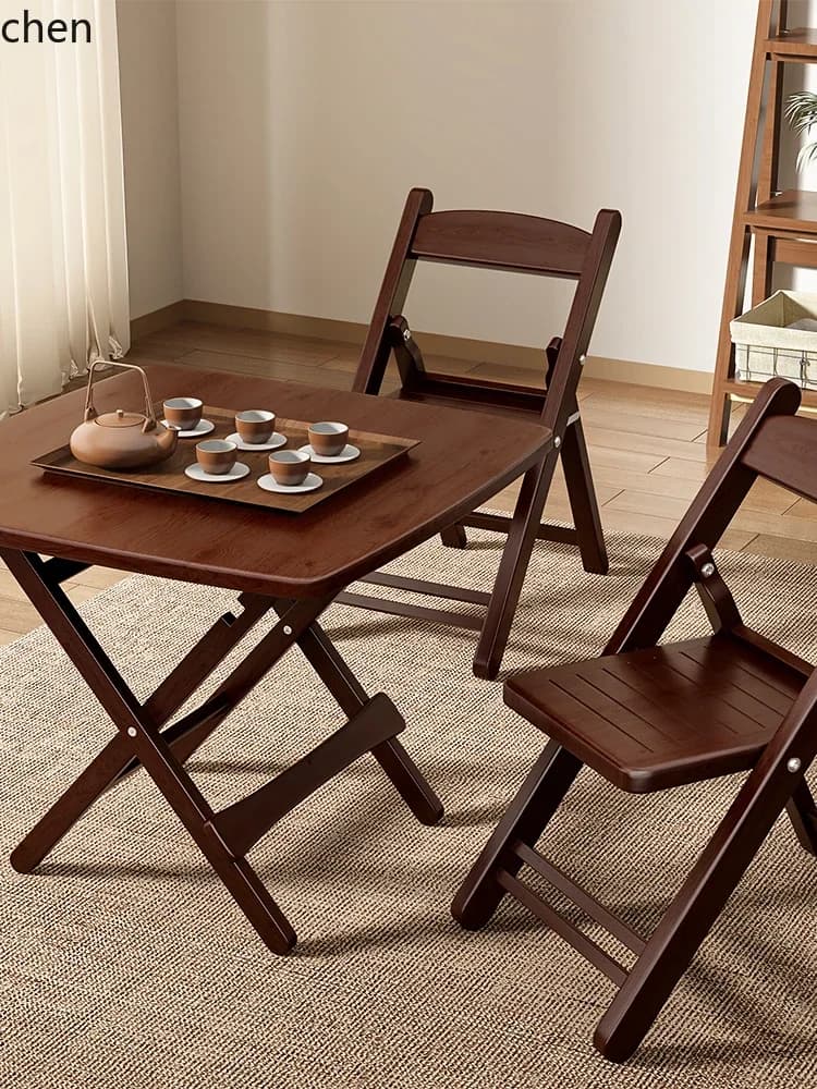 Dark walnut finished solid wood folding table and chairs set in a minimalist room.
