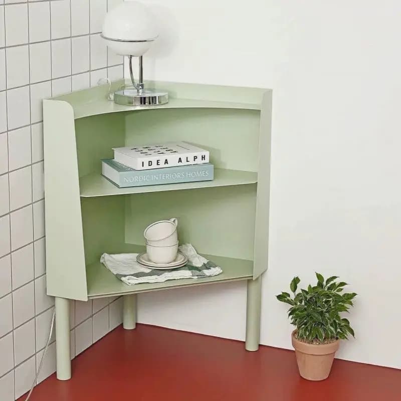 Mint green modern floor-to-ceiling corner bookshelf with two open shelves holding books and a lamp.