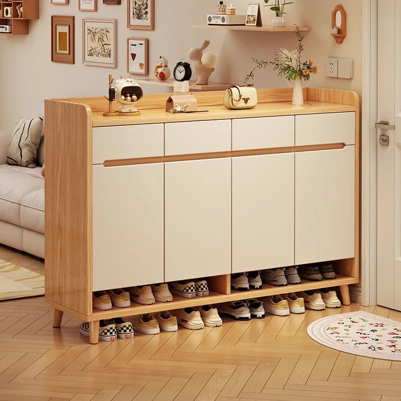 Modern solid wood shoe cabinet with light wood finish and white doors in a cozy entryway setting.