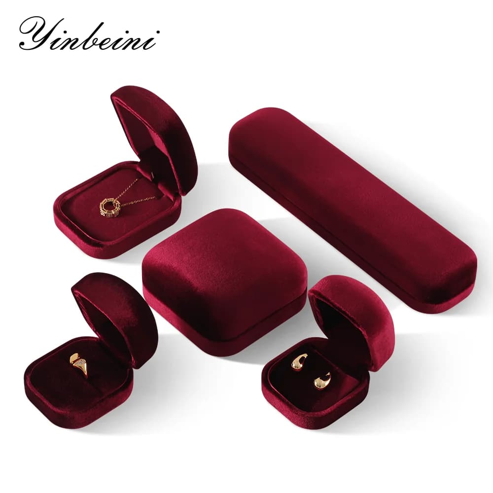 A collection of elegant deep red velvet jewelry boxes for rings, earrings, and necklaces.