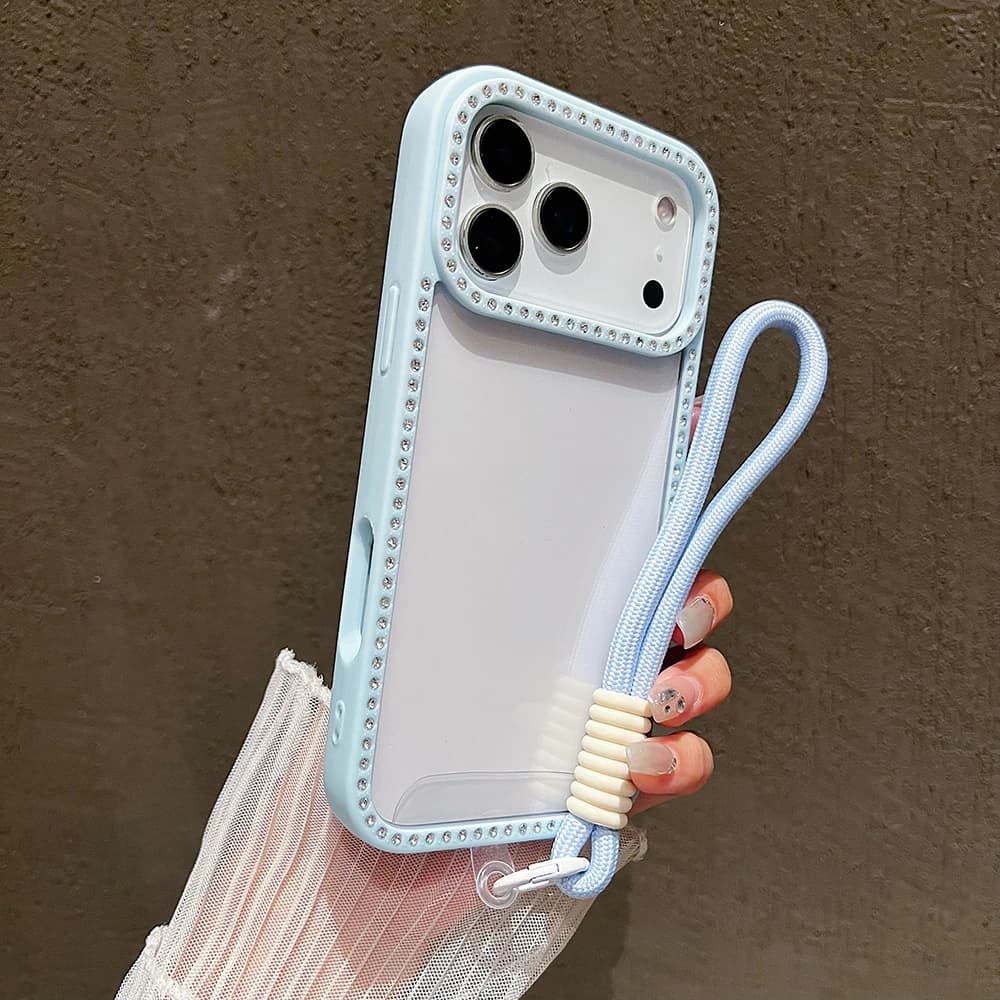 Light blue transparent iPhone case with diamond-studded edges and a matching woven wrist strap.
