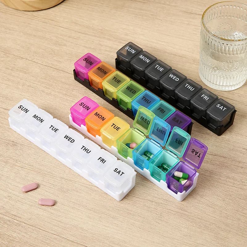 Various 7-day weekly pill organizers in rainbow and solid black colors with removable daily pods.