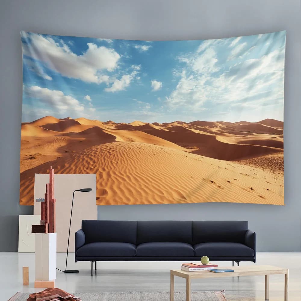 Large wall tapestry featuring golden desert sand dunes under a bright blue sky with clouds.