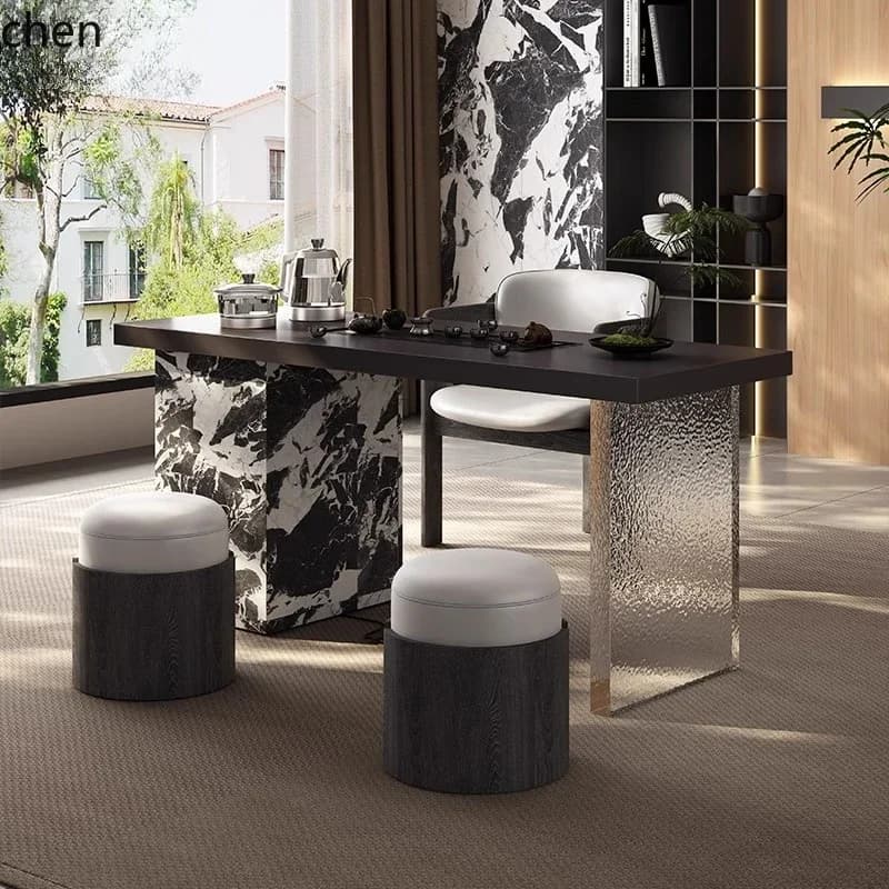 Modern minimalist tea table with marble-patterned base and textured glass support alongside contemporary seating.