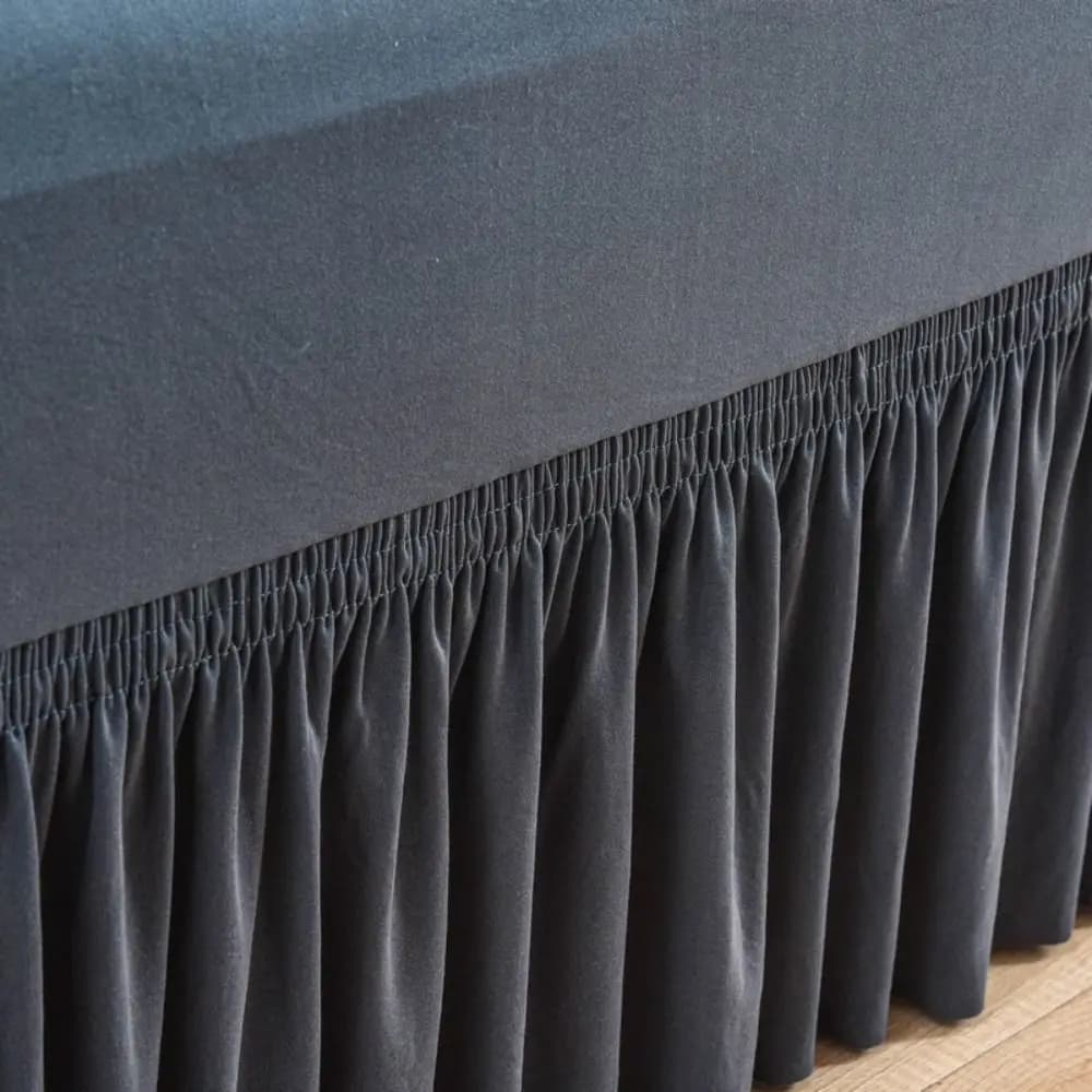 Close-up of a charcoal grey pleated sofa slipcover showing elastic detail.