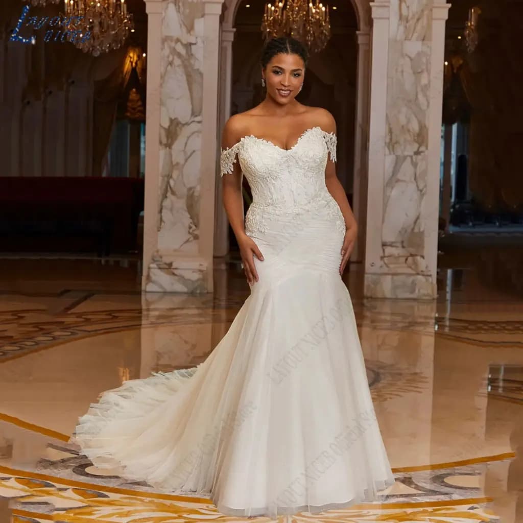 Bride wearing a white off-shoulder mermaid wedding dress with tulle and lace appliques.