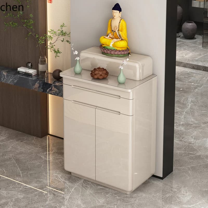 Minimalist cream-colored Buddhist altar cabinet with a Buddha statue on top in a modern living room setting.