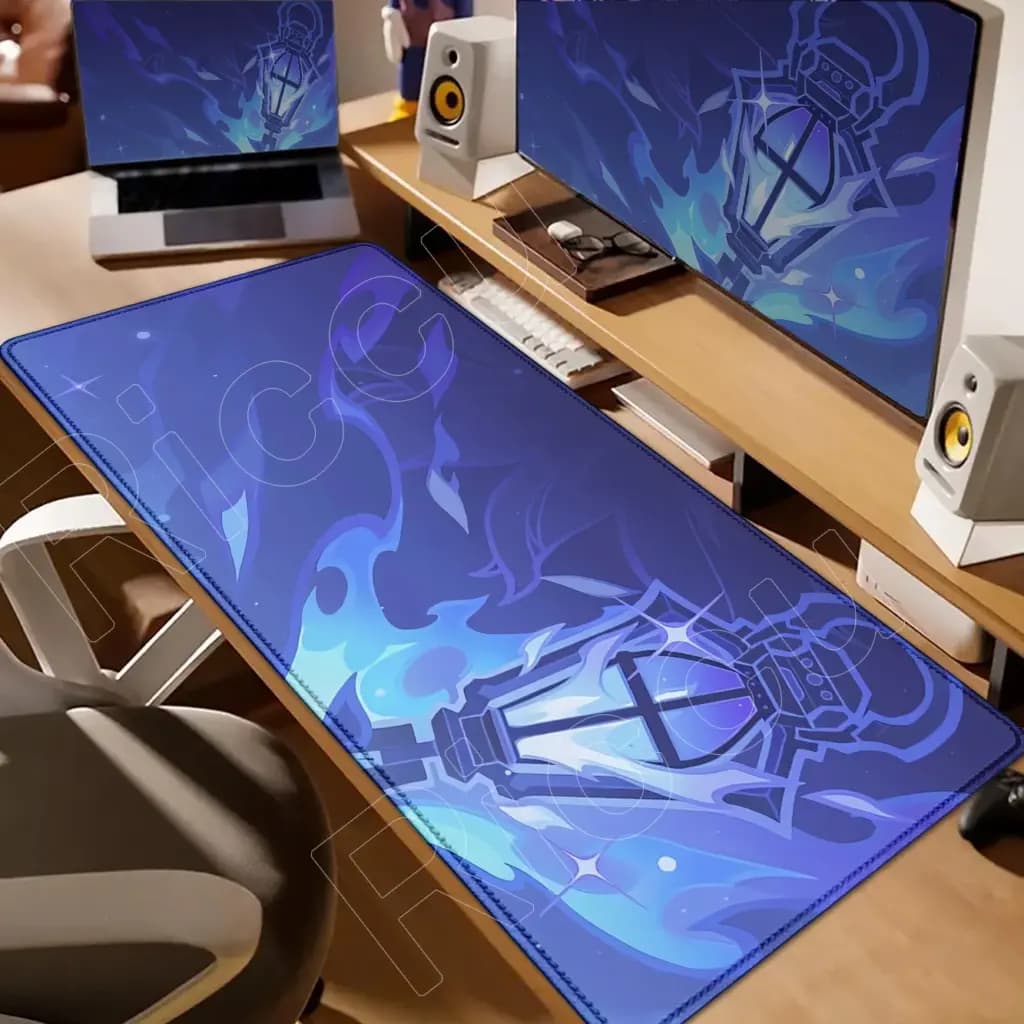 Extra large blue Genshin Impact themed gaming mouse pad displayed on a wooden desk with a computer and speakers.