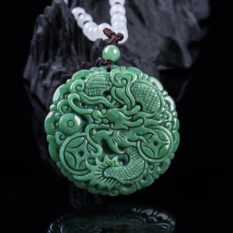 Intricately carved green ice jadeite dragon pendant on a beaded necklace.